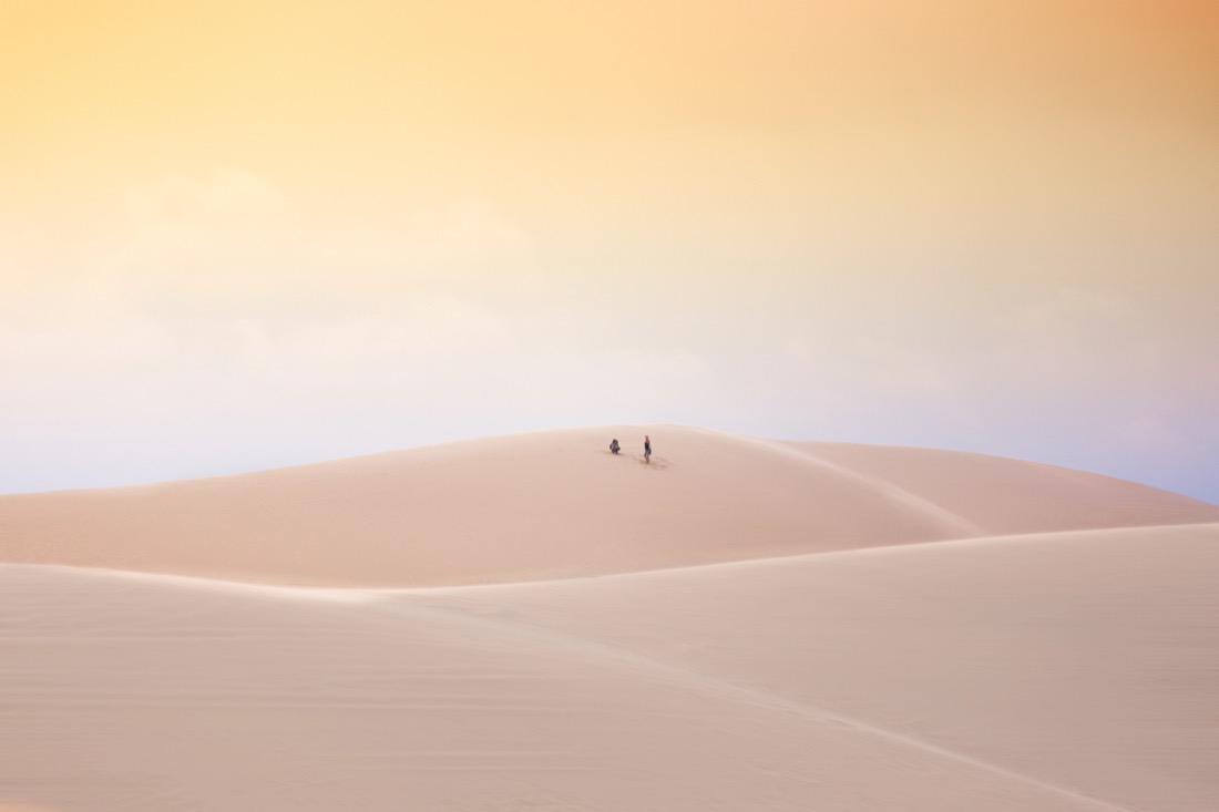 Couple in distance walking on sand dunes in Vietnam