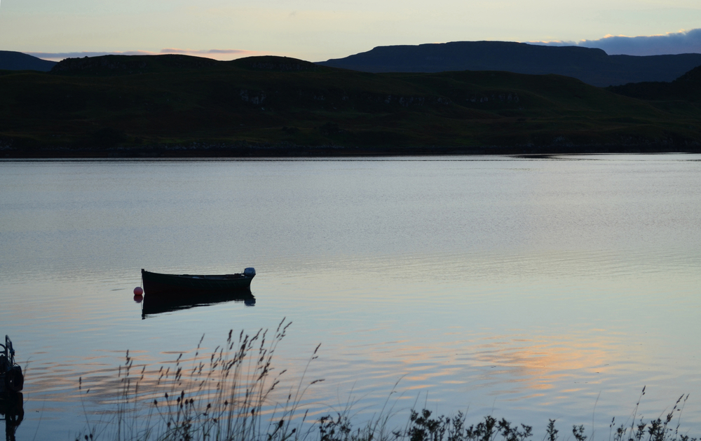 shutterstock 544399615 | Two Scots Abroad Silhouetted dinghy boat on a Scottish loch in the Highlands
