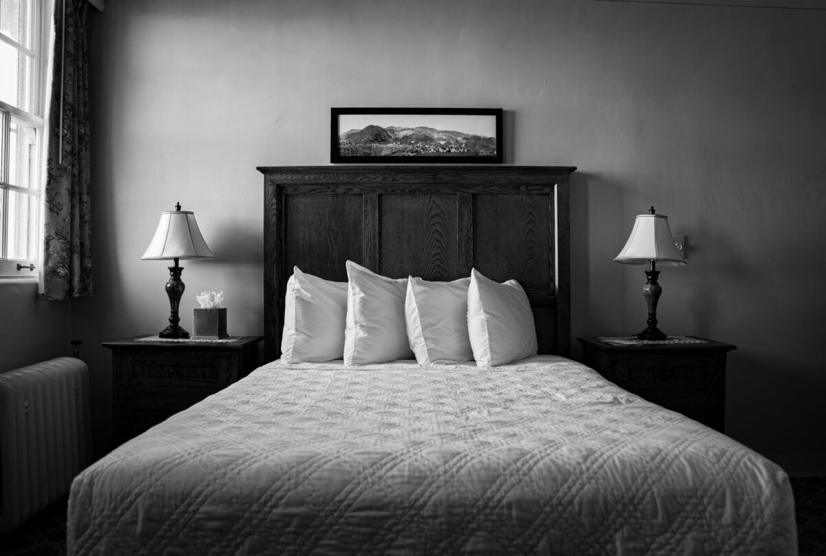 Beautifully decorated bedroom with classic furniture and soft lighting, captured in black and white.