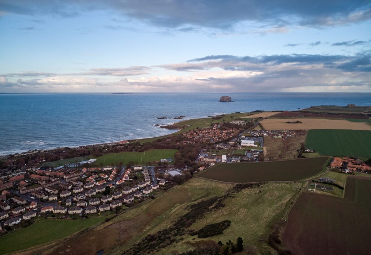 Panoramic aerial view of a coastal town in East Lothian, Scotland with beautiful landscapes and the sea horizon.