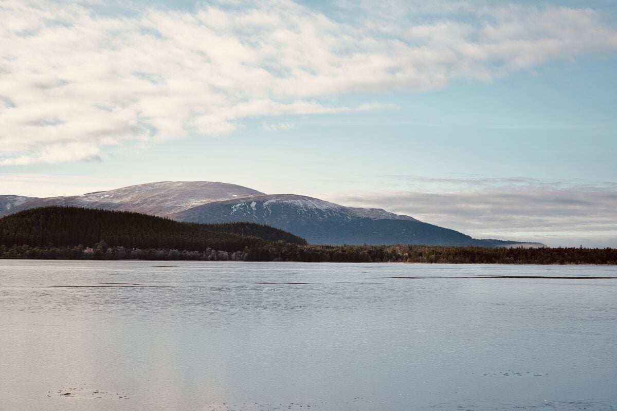 Serene landscape of mountains and lake in Aviemore, Scotland.