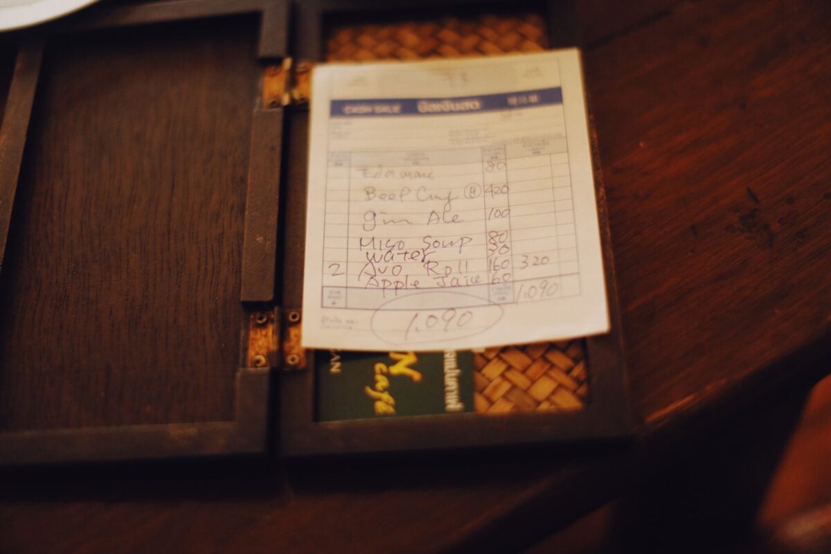pexels 11364283 | Two Scots Abroad Close-up of a restaurant bill placed on a dark wooden table, creating a moody ambiance.