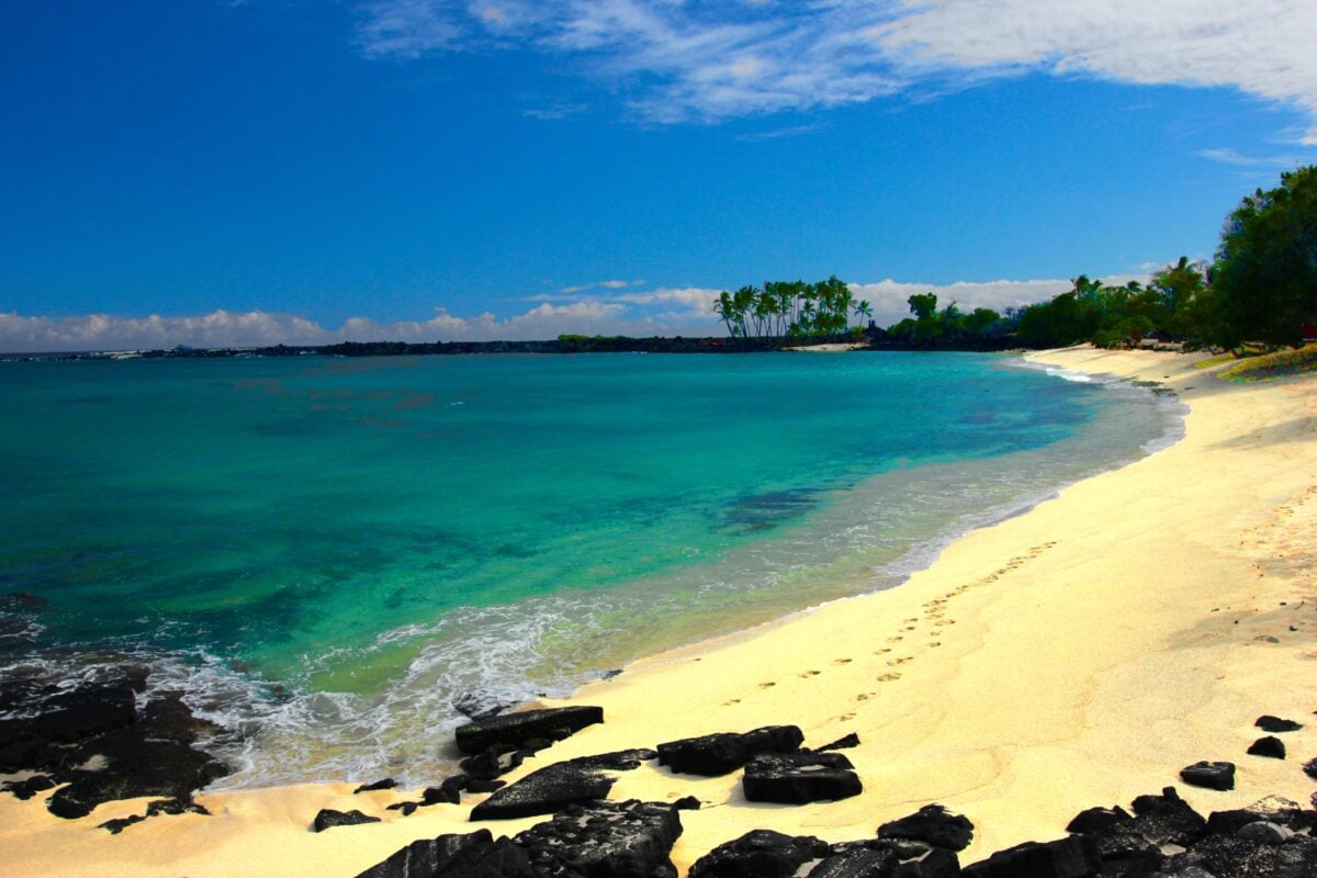Experience the serene beauty of a tropical beach in Hawaii with turquoise waters and golden sands.