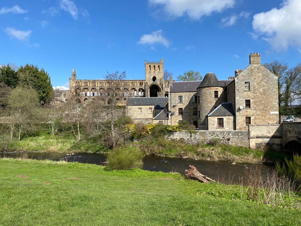pexels 16941330 | Two Scots Abroad Beautiful view of the historic Jedburgh Abbey and nearby buildings under a bright blue sky in Scotland.
