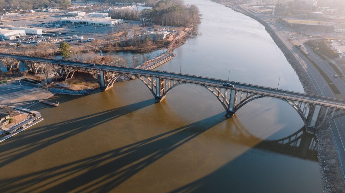 Stunning aerial shot of a bridge crossing over a calm river in Gadsden, Alabama during sunset. Bibb County