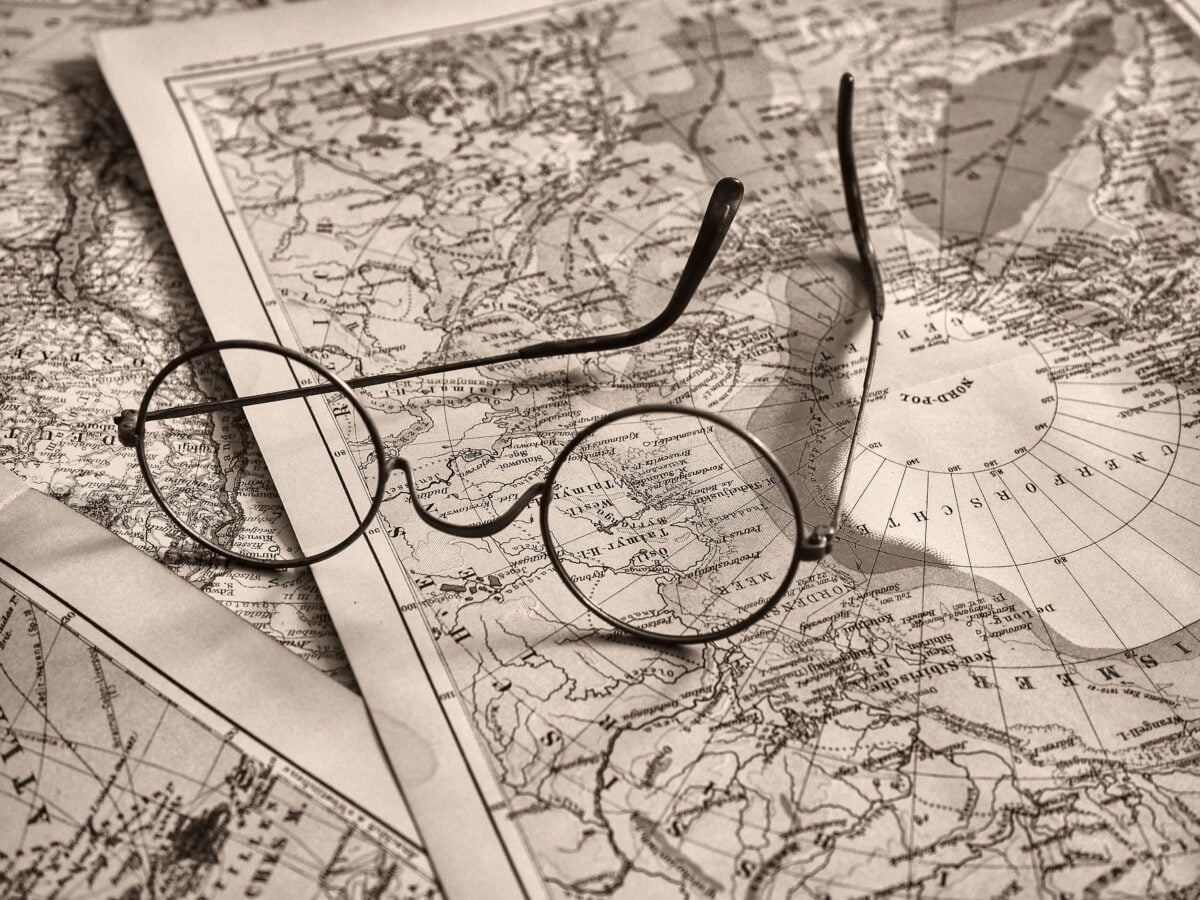 pexels 20067918 | Two Scots Abroad Round eyeglasses rest on an antique world map, evoking a sense of exploration.