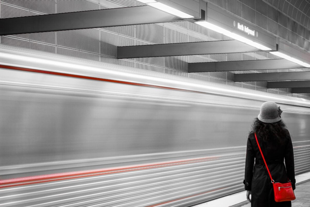 pexels 2233865 | Two Scots Abroad A woman stands at North Hollywood Metro Station as a train speeds by, capturing urban transit dynamics.