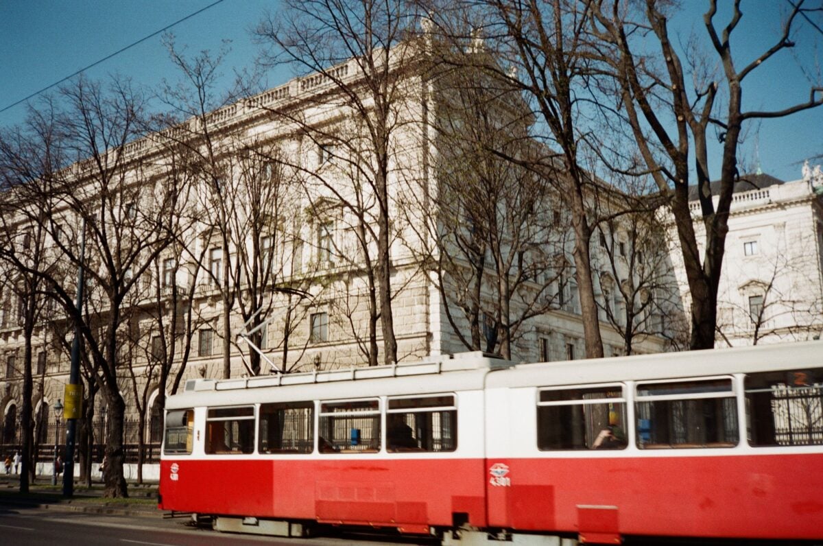 pexels 25309889 | Two Scots Abroad Captured in Vienna, this image features a vintage tram against historic architecture and bare trees in spring.