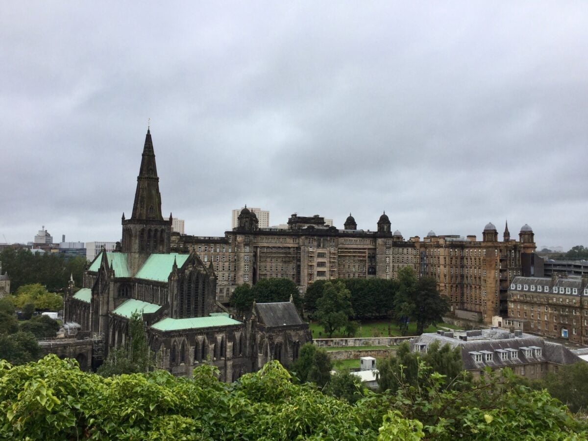 pexels 32314227 | Two Scots Abroad View of Glasgow Cathedral and cityscape under cloudy skies, showcasing gothic architecture.