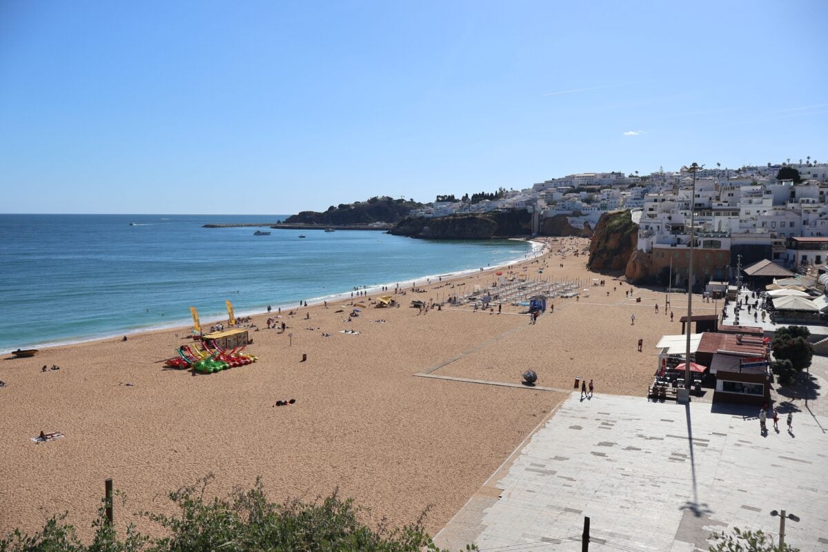 pexels 32675323 | Two Scots Abroad Aerial view of Albufeira beach, Algarve, on a sunny day with ocean waves and coastal town backdrop.