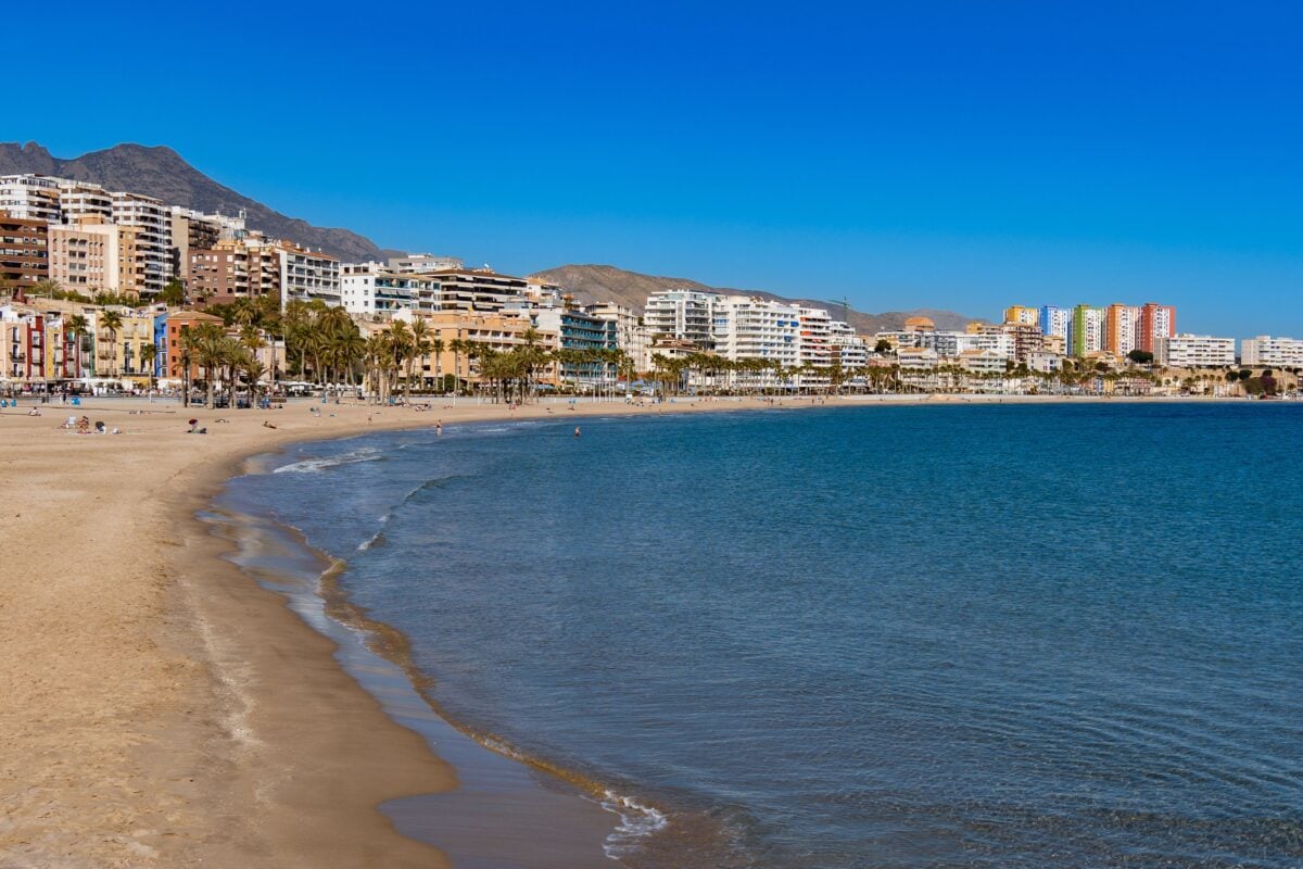 pexels 34894050 | Two Scots Abroad Coastal view of Villajoyosa with beach and colorful buildings under a clear sky.
