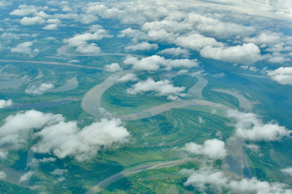 pexels 36441962 | Two Scots Abroad A breathtaking aerial view of a meandering river in Papua, Indonesia, surrounded by lush greenery and clouds.