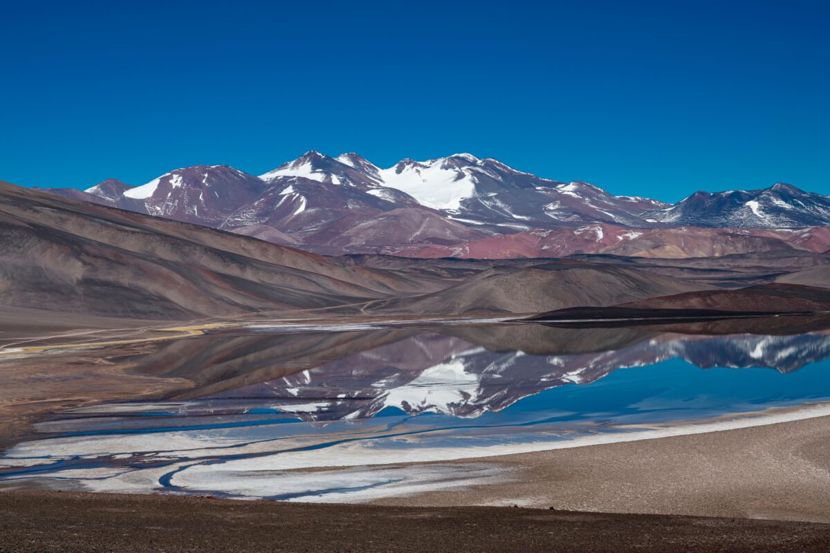 pexels 37610517 | Two Scots Abroad Scenic view of snow-capped mountains reflecting in a tranquil lake in Catamarca, Argentina.