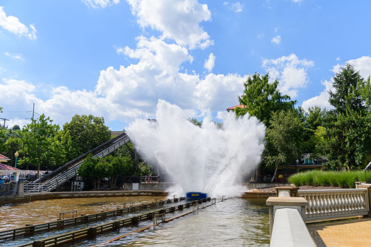 Thrilling water ride splash at a sunny amusement park. Perfect for summer fun.
