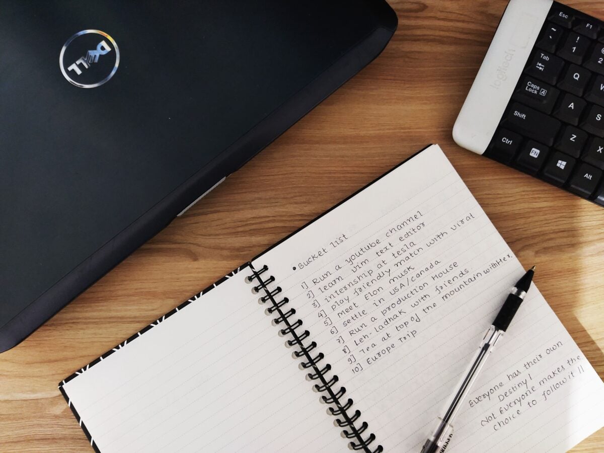 pexels 4810501 | Two Scots Abroad Flat lay of a workspace featuring a laptop, notebook, and keyboard on a wooden desk.