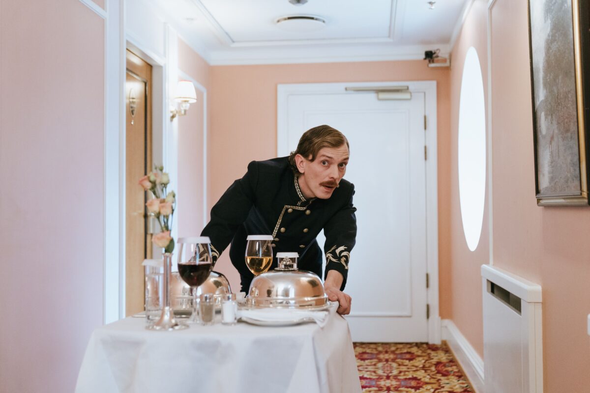 pexels 5371566 | Two Scots Abroad Hotel staff member in uniform serving room service in a luxurious corridor.