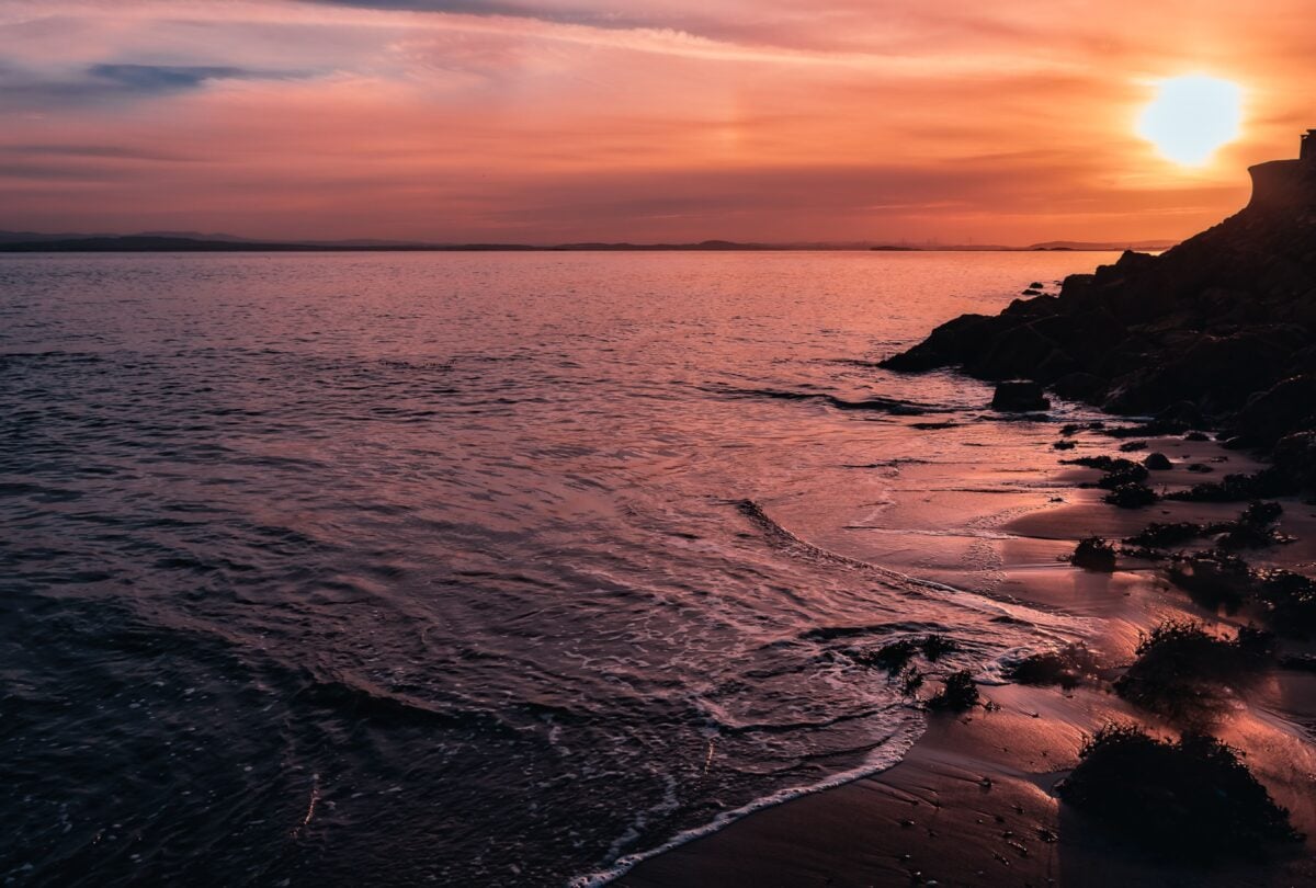pexels 6068559 | Two Scots Abroad Beautiful sunset over the North Sea from Kinghorn Beach, Scotland with bright orange skies and calm waters.