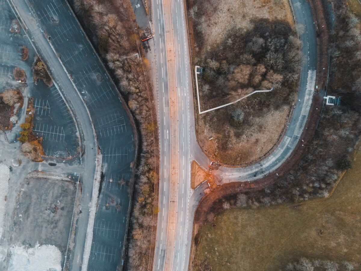 pexels 7519199 | Two Scots Abroad Drone shot of a road intersection surrounded by nature and parking areas in Scotland.