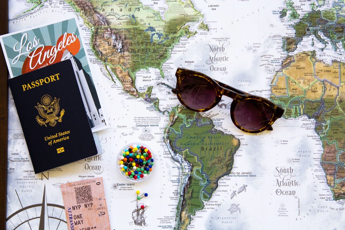 pexels 7662165 | Two Scots Abroad Flat lay of travel essentials with a world map, passport, and sunglasses.