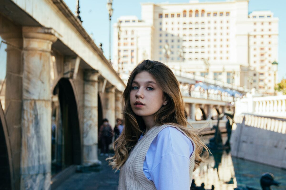 A young caucasian woman stands outdoors in Moscow, Russia.
