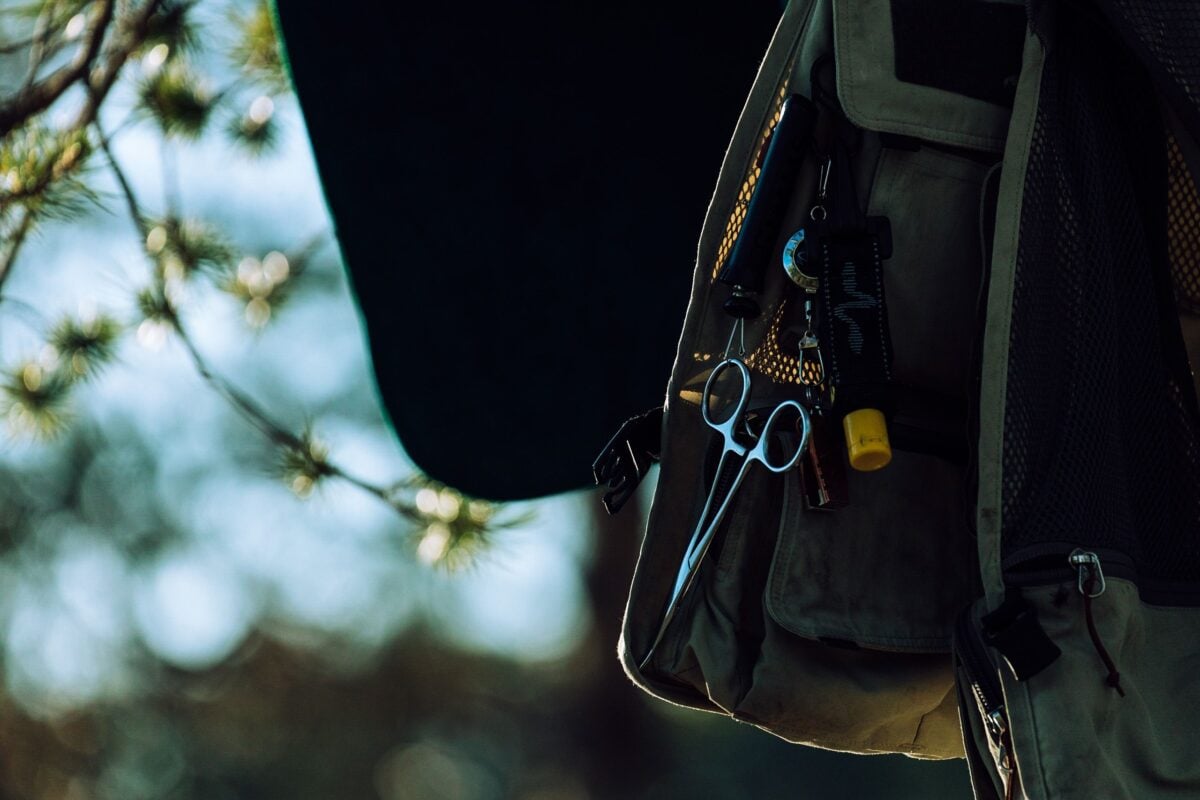 pexels 8983956 | Two Scots Abroad Close-up of a forester vest with tools and scissors outdoors among blurred trees.