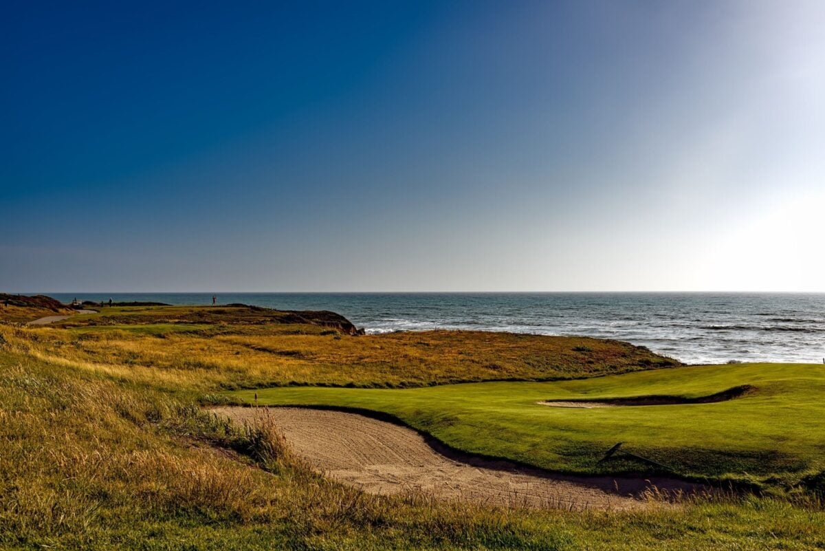 pexels 220026 | Two Scots Abroad Breathtaking view of a golf course along the coastline under a clear blue sky.