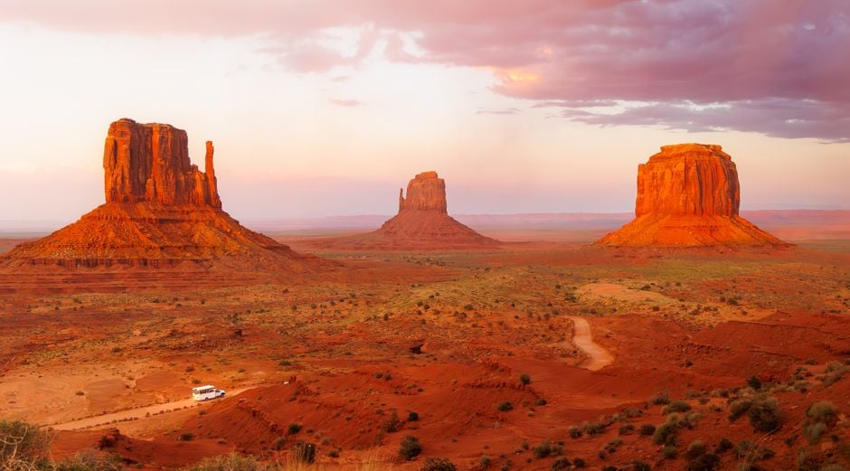 Stunning sunset view of Monument Valley's mesas and red rock formations in Arizona.
