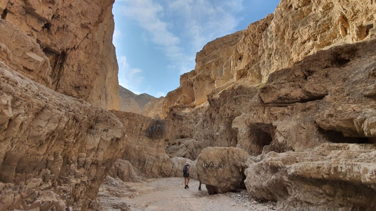 a lone hiker explores the rugged canyon cliffs in ein gedi israel on a sunny day | Two Scots Abroad A lone hiker explores the rugged canyon cliffs in Ein Gedi, Israel, on a sunny day.