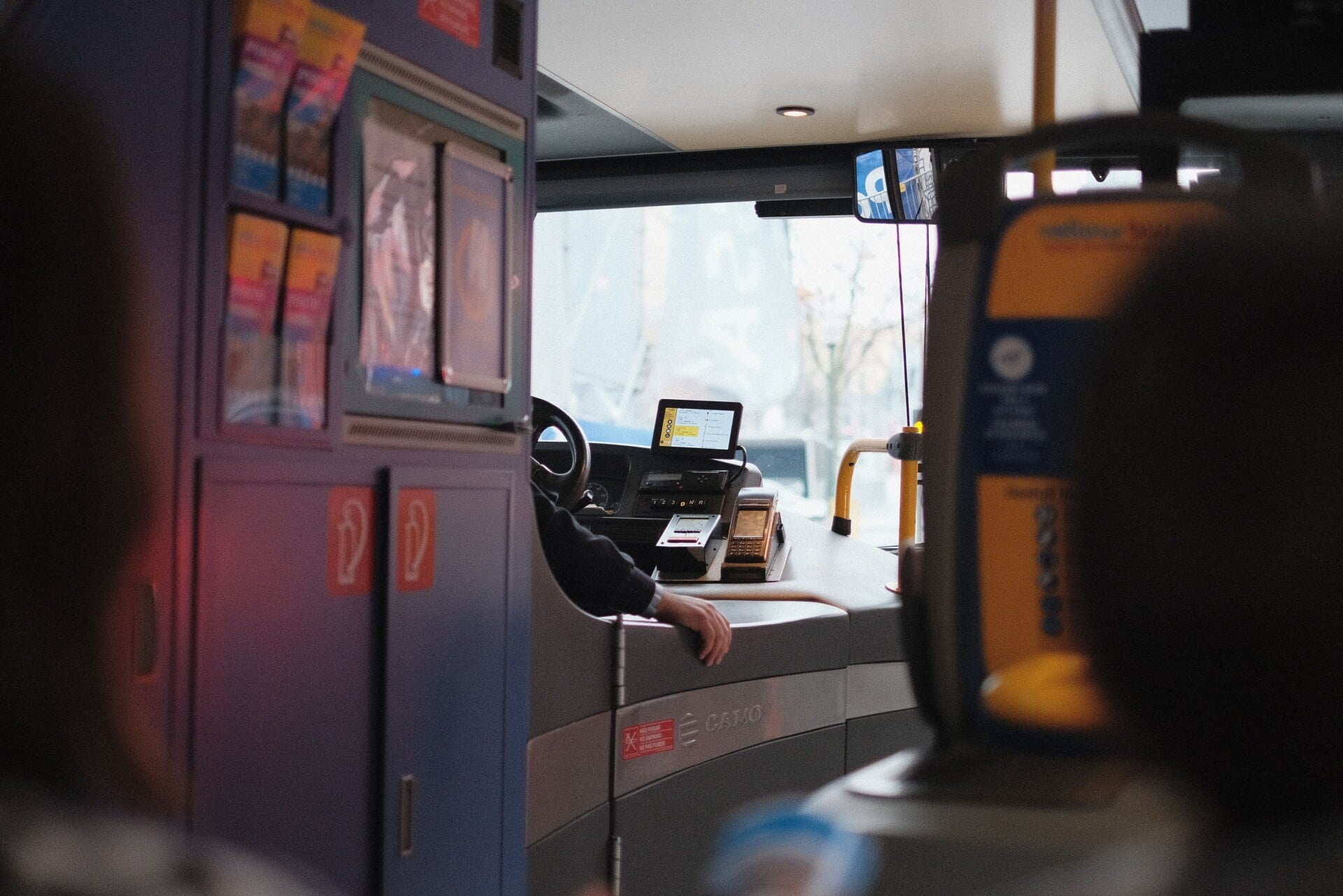 A modern bus interior showcasing the driver's area during daylight hours.