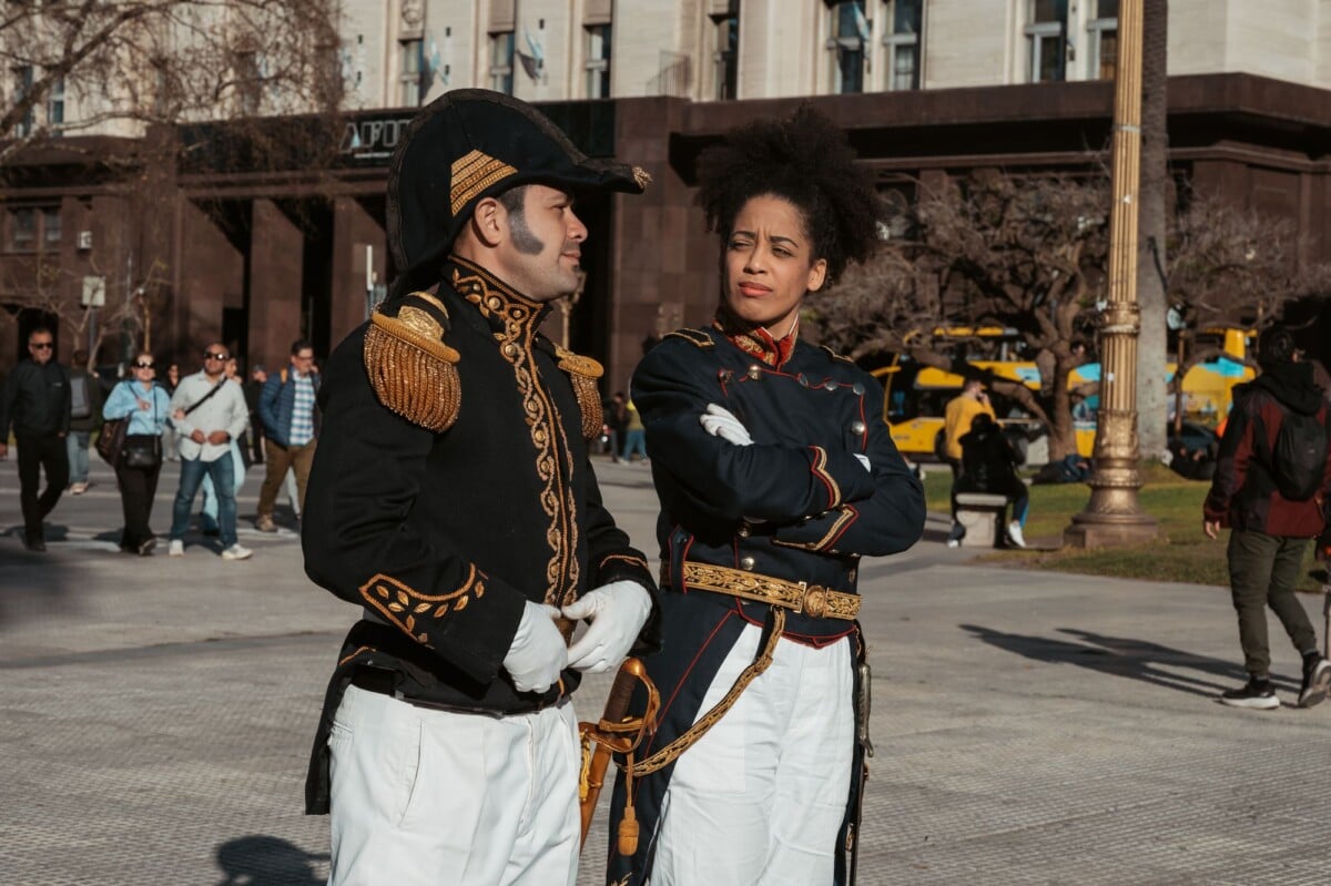 Actors in military uniforms reenacting historical events on a sunny day in Buenos Aires.