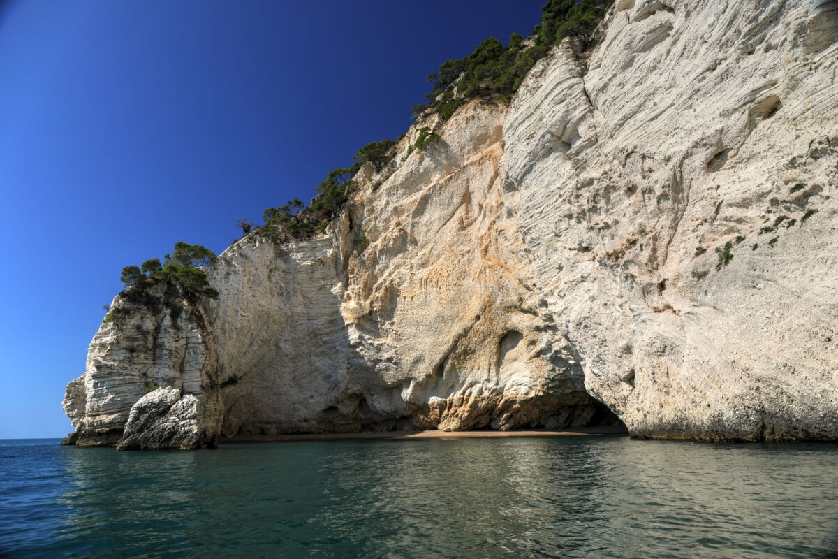 Beautiful coastal cliffs with clear blue sky in Vieste, Puglia, Italy.