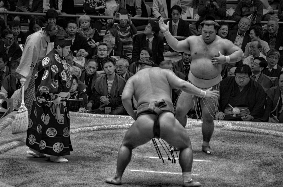 black and white image of a sumo wrestling bout in osaka japan showcasing the int | Two Scots Abroad Black and white image of a sumo wrestling bout in Osaka, Japan, showcasing the intensity and tradition of this ancient sport.
