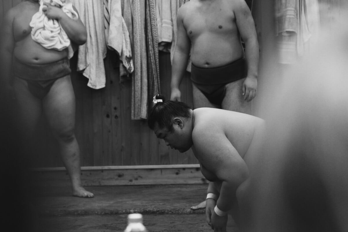 black and white image of sumo wrestlers in tokyo japan showcasing cultural tradi | Two Scots Abroad Black and white image of sumo wrestlers in Tokyo, Japan, showcasing cultural traditions and preparation rituals.