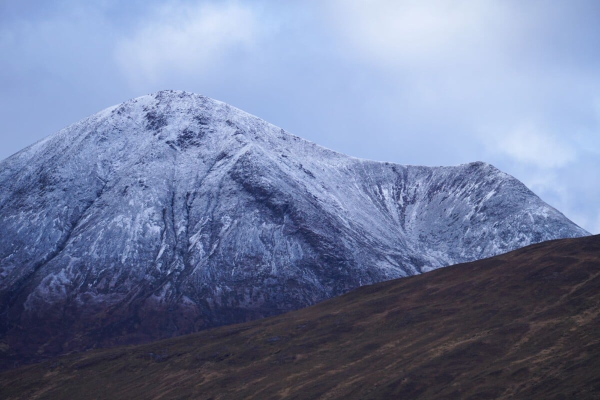 Breathtaking view of a snow-covered mountain under a cloudy sky.