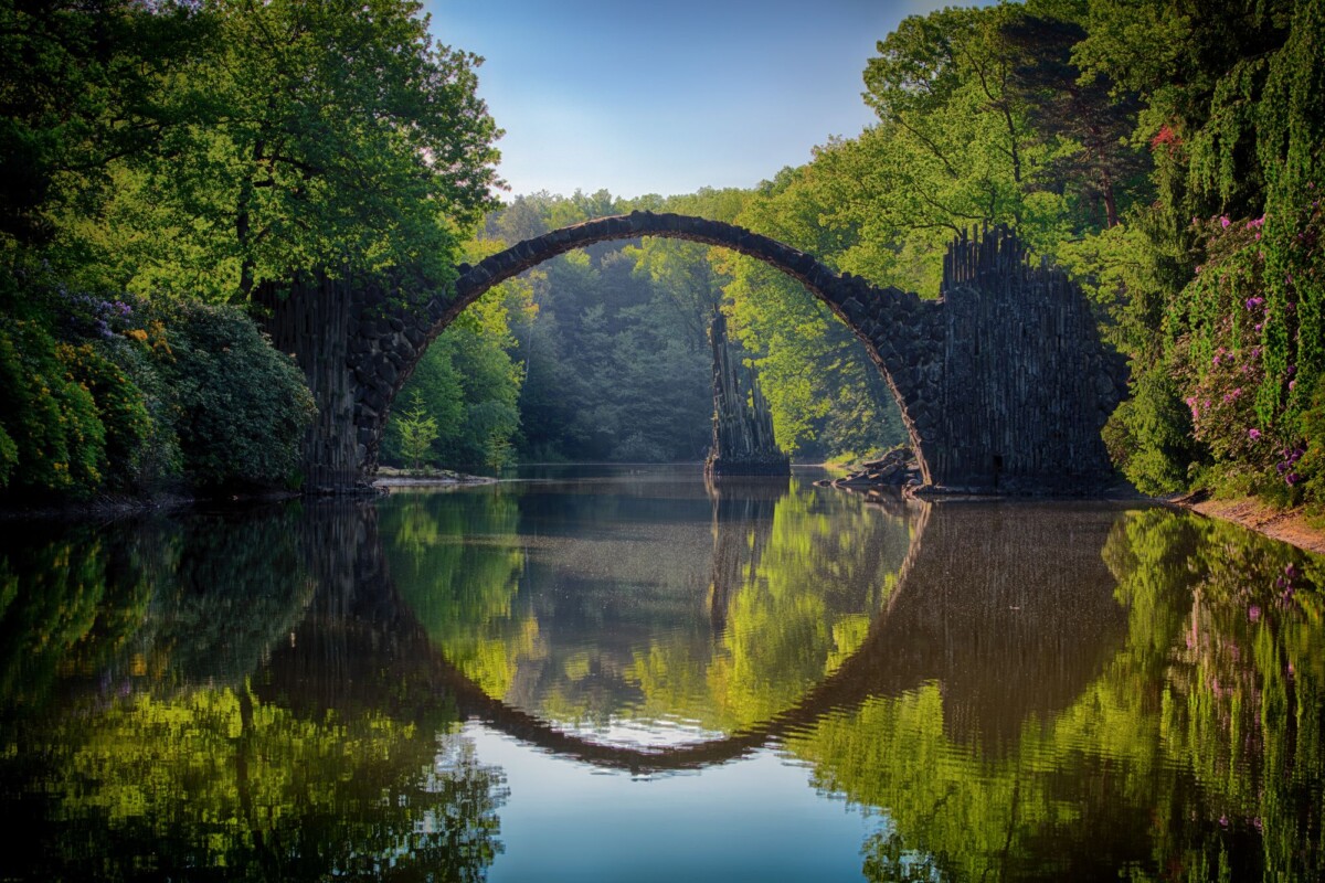 capture of the iconic rakotzbrucke reflecting in calm waters amidst lush greener | Two Scots Abroad Capture of the iconic Rakotzbrücke reflecting in calm waters amidst lush greenery in Germany.