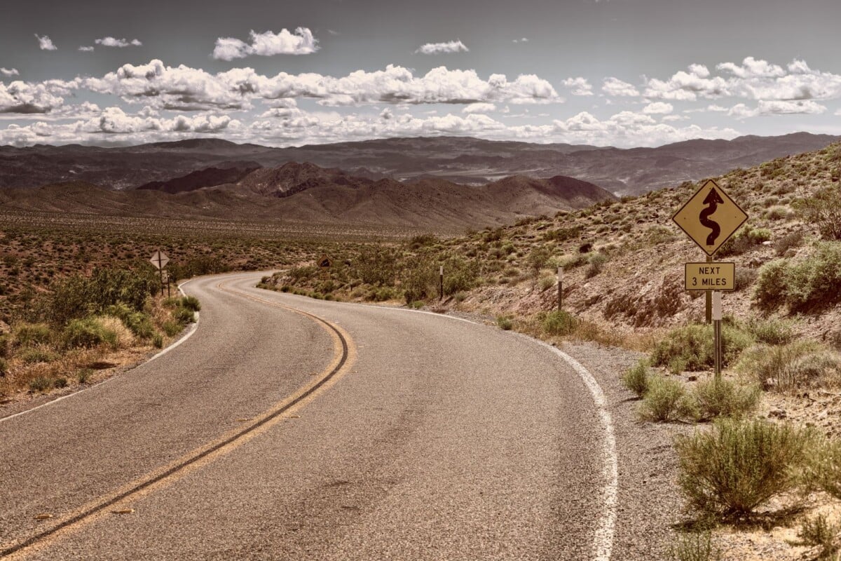 curved desert road in arid landscape with mountains and clear sky | Two Scots Abroad Curved desert road in arid landscape with mountains and clear sky