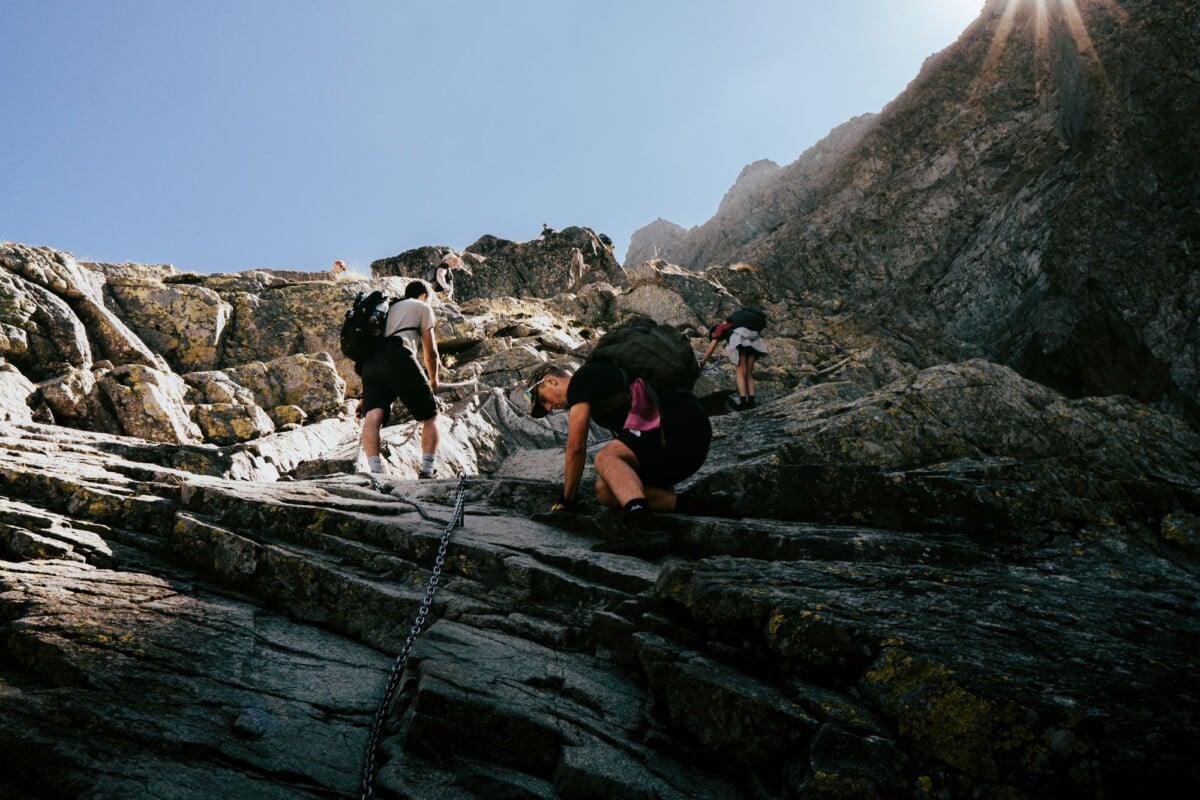 Hikers climbing a steep rocky mountain slope in the Tatras, Poland.