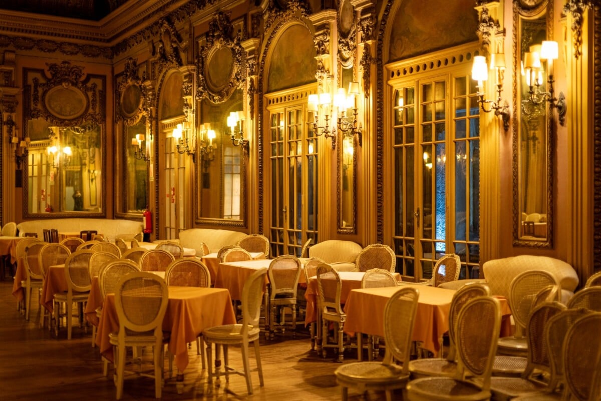Luxurious dining room in a historic Lisbon restaurant with ornate decor and soft lighting.