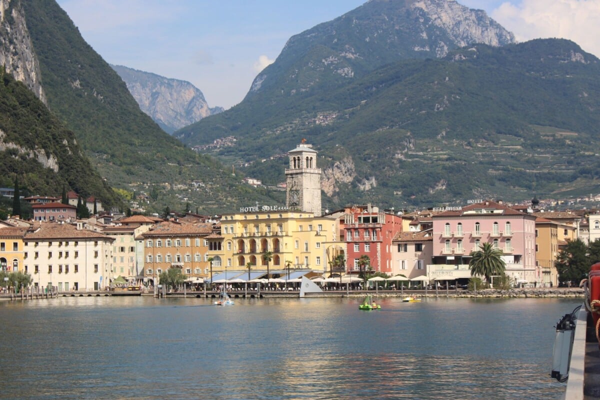 Scenic view of an Italian lakeside town surrounded by mountains in summer.