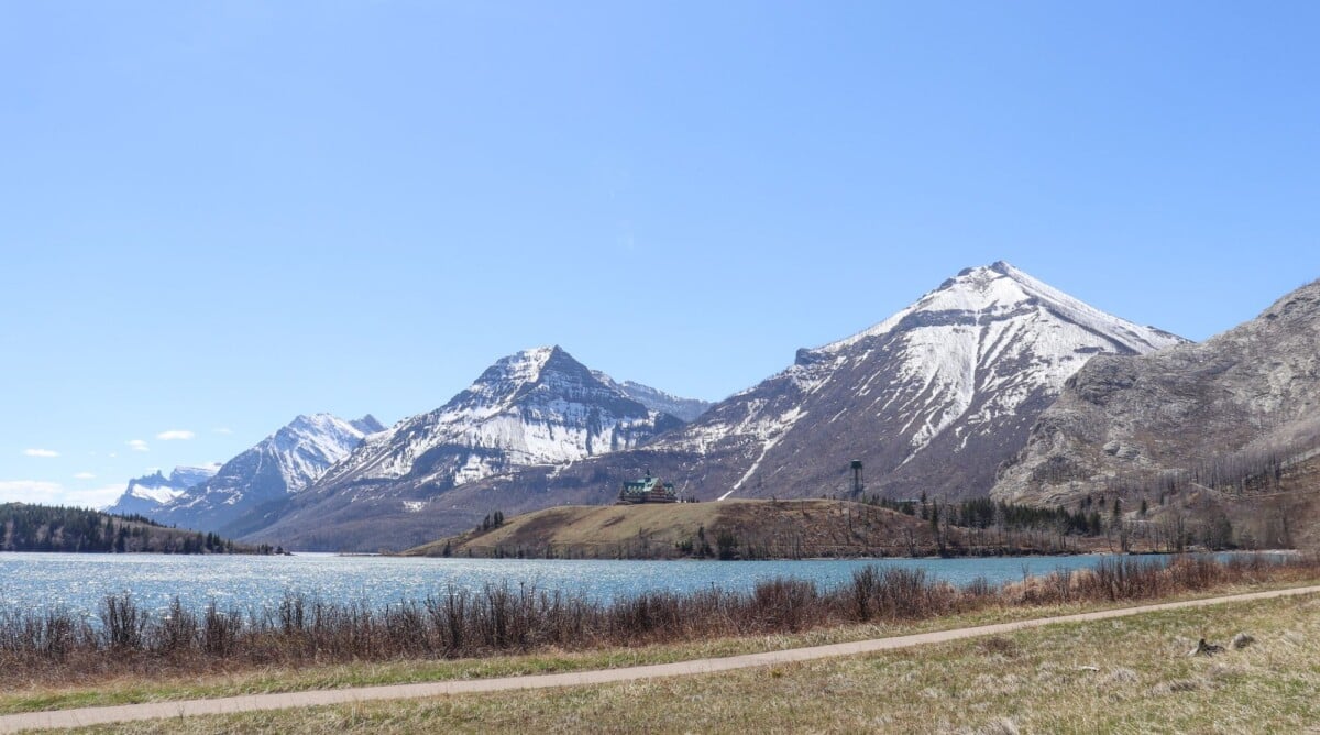 snowy mountains overlooking a serene alpine lake under a clear blue sky | Two Scots Abroad Snowy mountains overlooking a serene alpine lake under a clear blue sky.