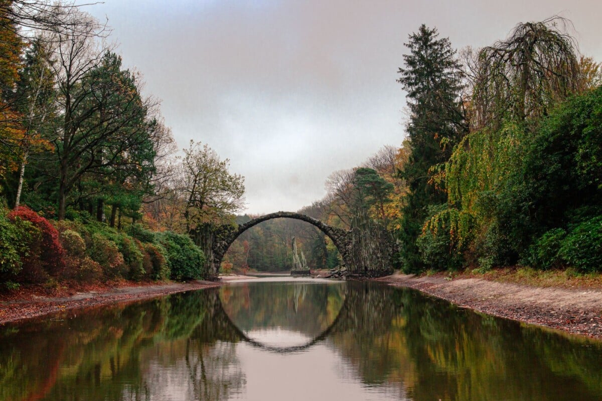 stone arch bridge reflected in a peaceful river surrounded by colorful autumn fo | Two Scots Abroad Stone arch bridge reflected in a peaceful river surrounded by colorful autumn foliage.