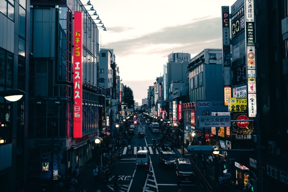 street view in tokyos downtown district filled with neon signs and traffic durin | Two Scots Abroad Street view in Tokyo's downtown district filled with neon signs and traffic during twilight.