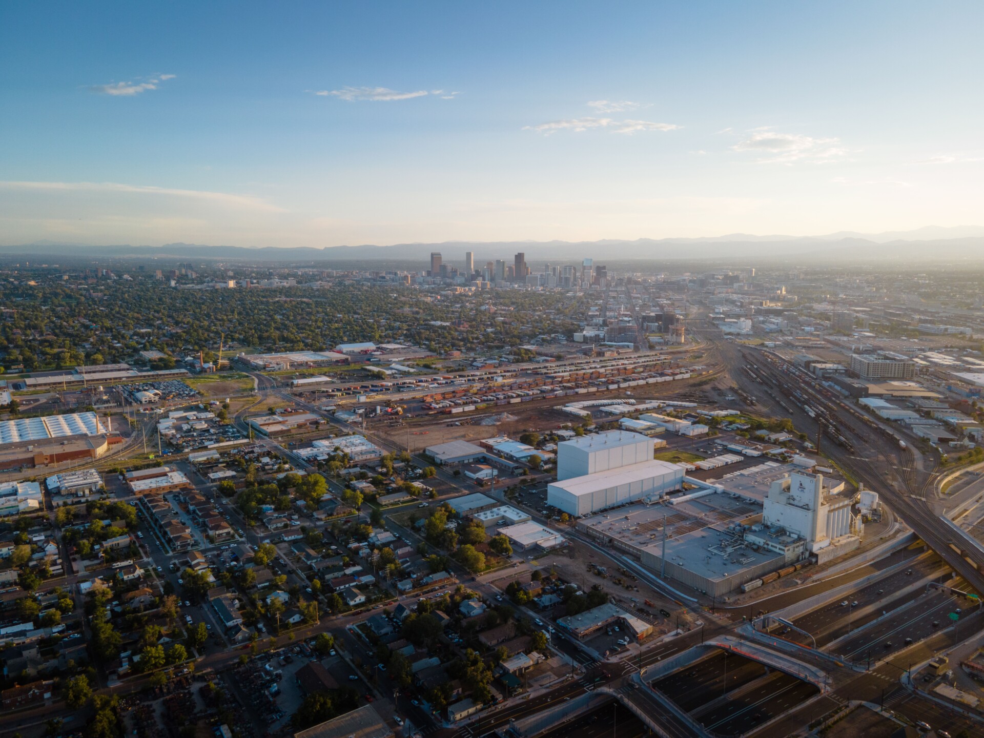 Stunning aerial view of Denver cityscape with urban sprawl and distant skyline at dusk.