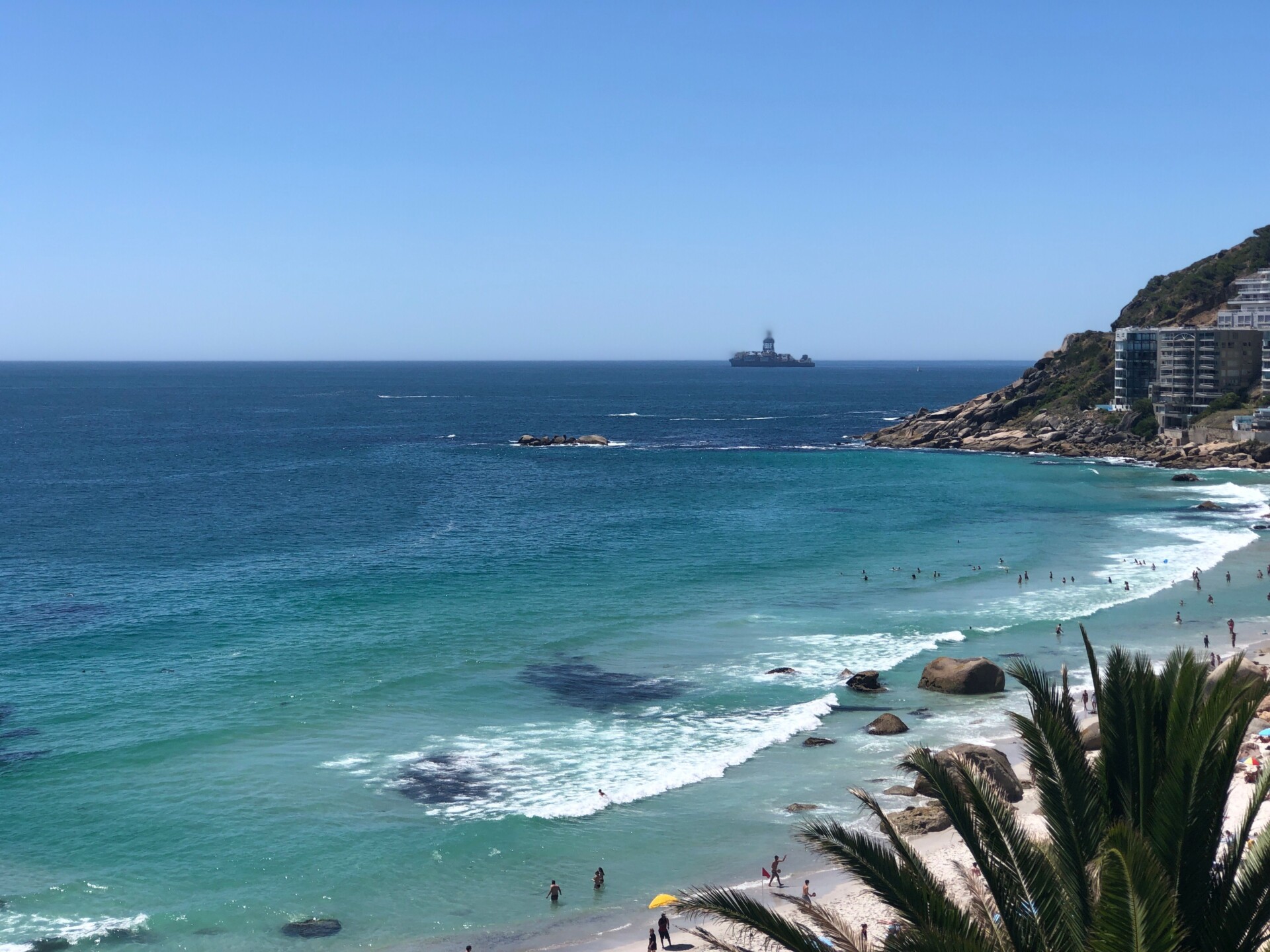 Stunning view of Clifton Beach with clear blue water and distant ship in Cape Town.