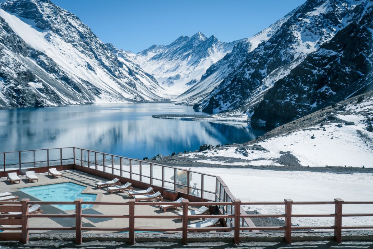 stunning view of snow covered andes mountains and pristine lake in chile with po | Two Scots Abroad Stunning view of snow-covered Andes mountains and pristine lake in Chile with poolside foreground.