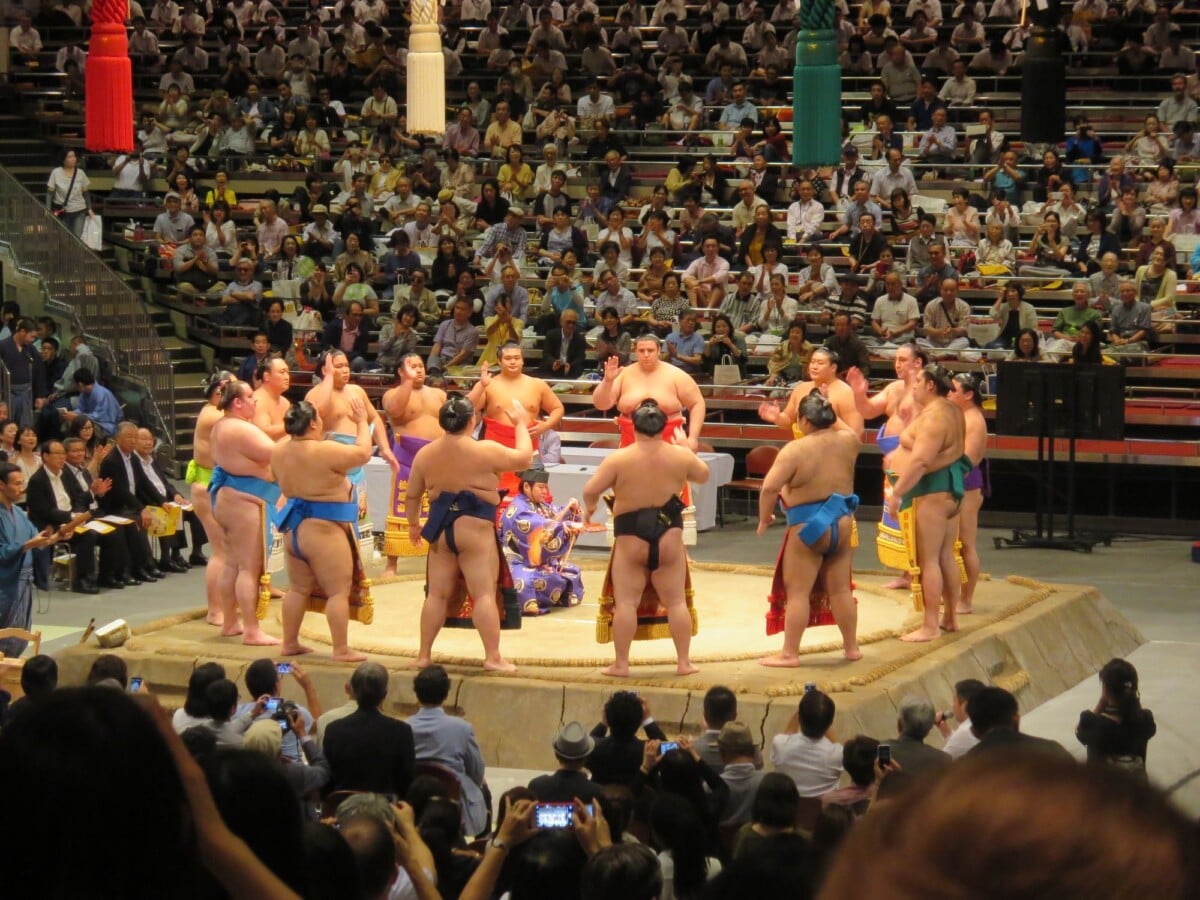sumo wrestlers gathered in a tokyo arena during a traditional match | Two Scots Abroad Sumo wrestlers gathered in a Tokyo arena during a traditional match.