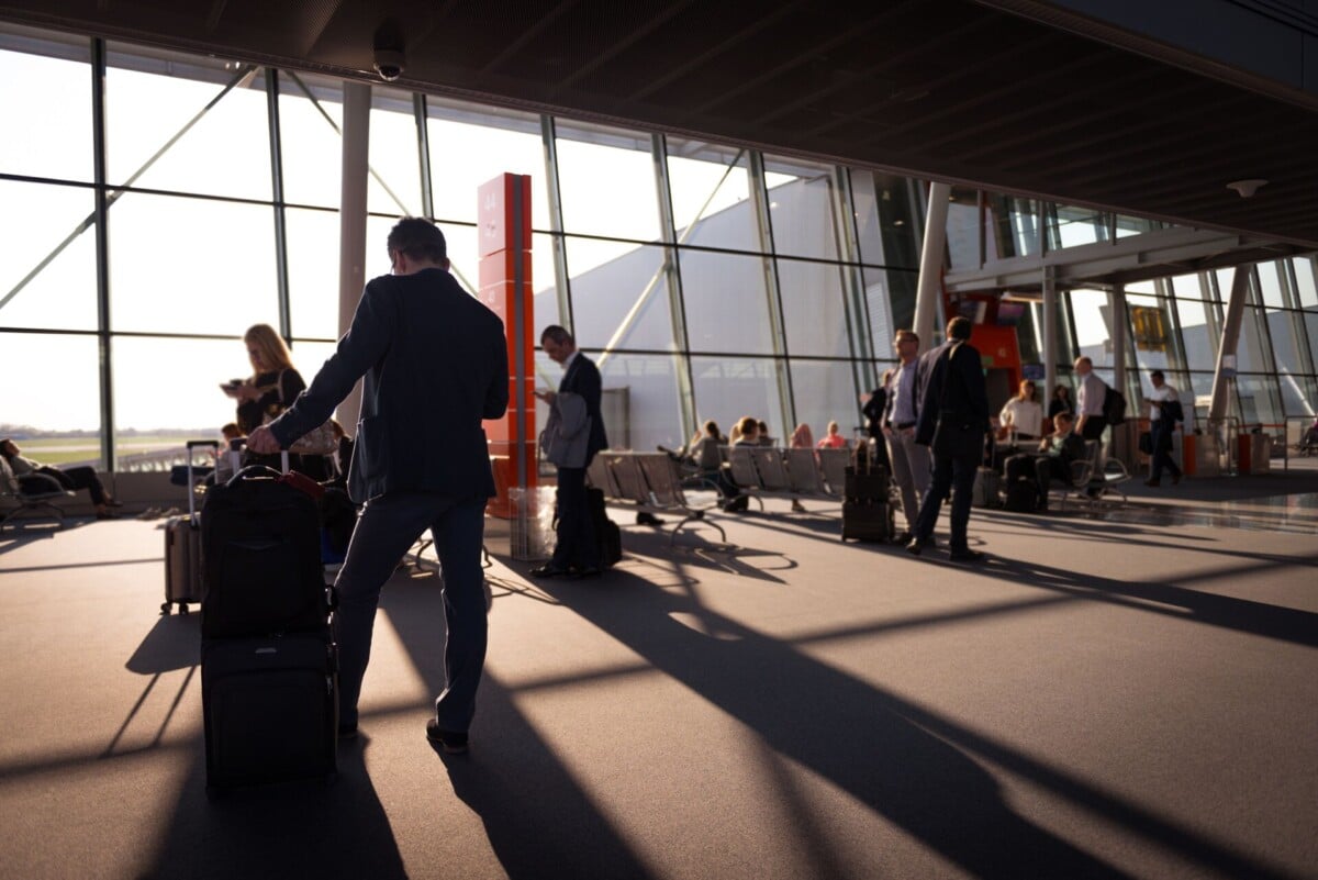 travelers in a bustling airport terminal with carry on luggage waiting for depar 1 | Two Scots Abroad Travelers in a bustling airport terminal with carry-on luggage waiting for departure.