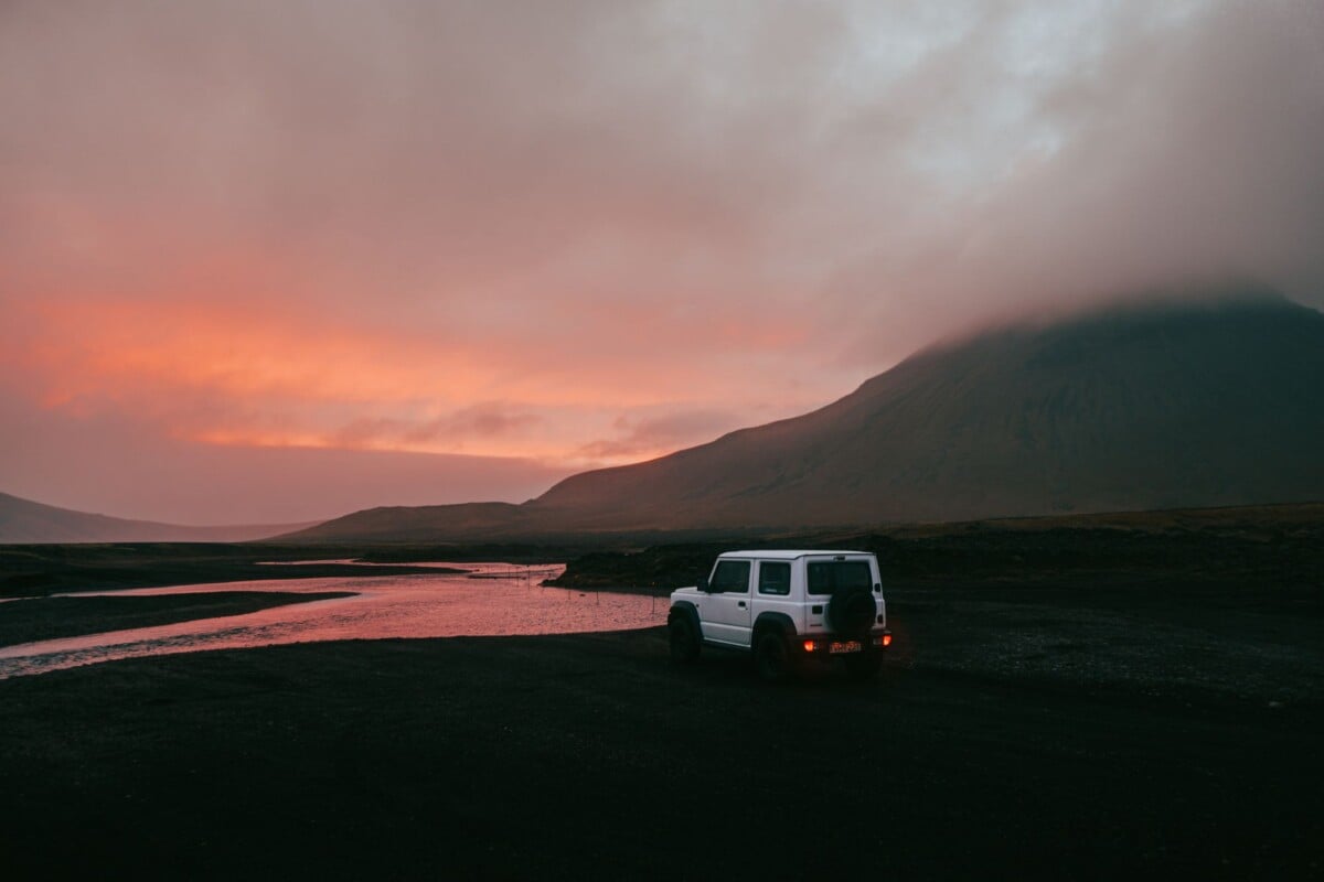 white suzuki jimny facing a scenic river in iceland during a vibrant sunset | Two Scots Abroad White Suzuki Jimny facing a scenic river in Iceland during a vibrant sunset.