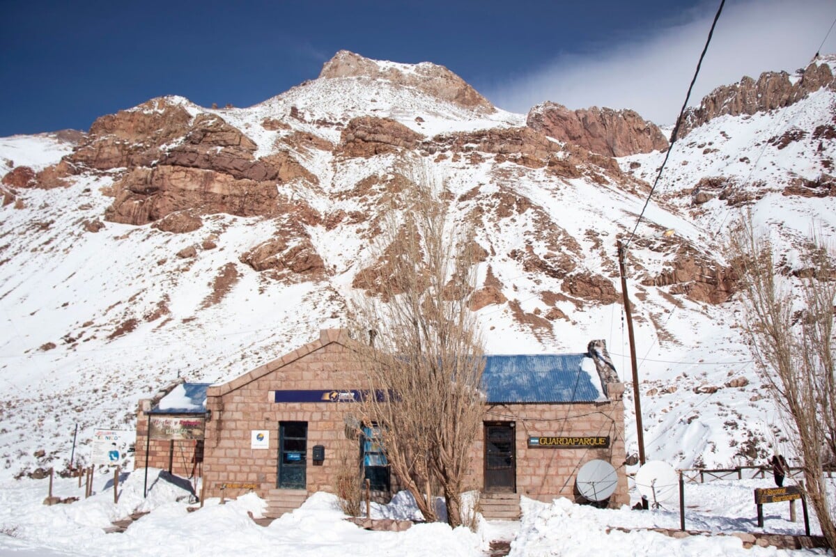 Winter scene of a post office in Los Penitentes, Mendoza, Argentina, with snow-covered mountains.