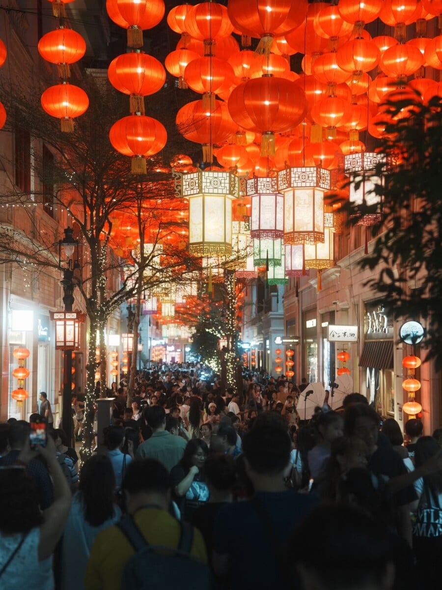 a bustling hong kong street illuminated by vibrant red lanterns during a festive | Two Scots Abroad A bustling Hong Kong street illuminated by vibrant red lanterns during a festive celebration at night.